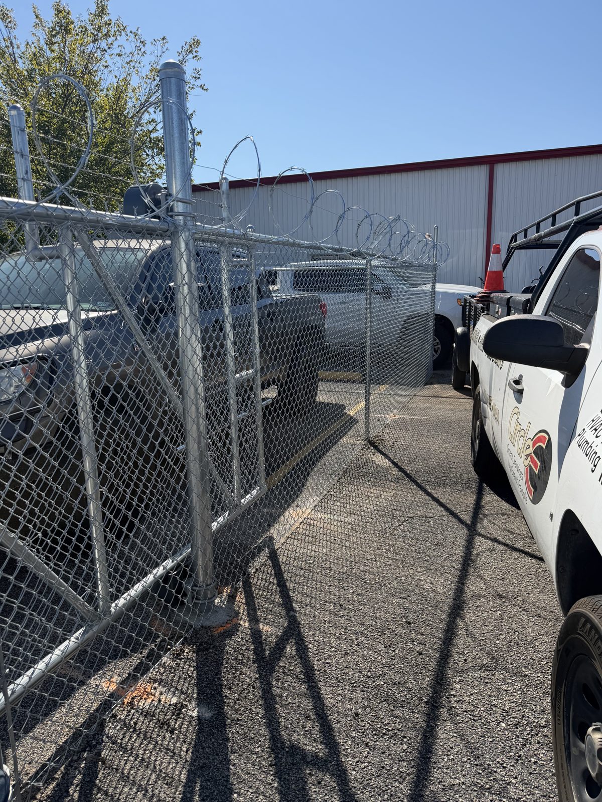 Chain link fence corner with razor wire topping at a commercial lot