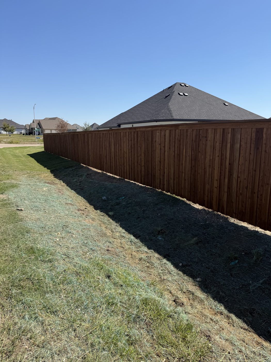 Wood privacy fence line along a backyard